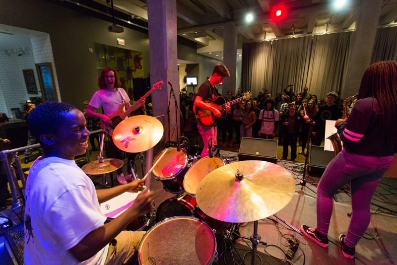 Teen band performing in front of an audience.