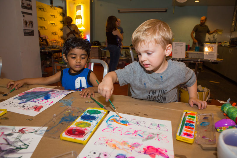 Two children are watercolor painting together.