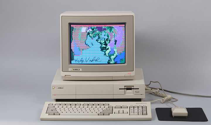 An old Amiga computer with a colorful self portrait of Andy Warhol on the screen