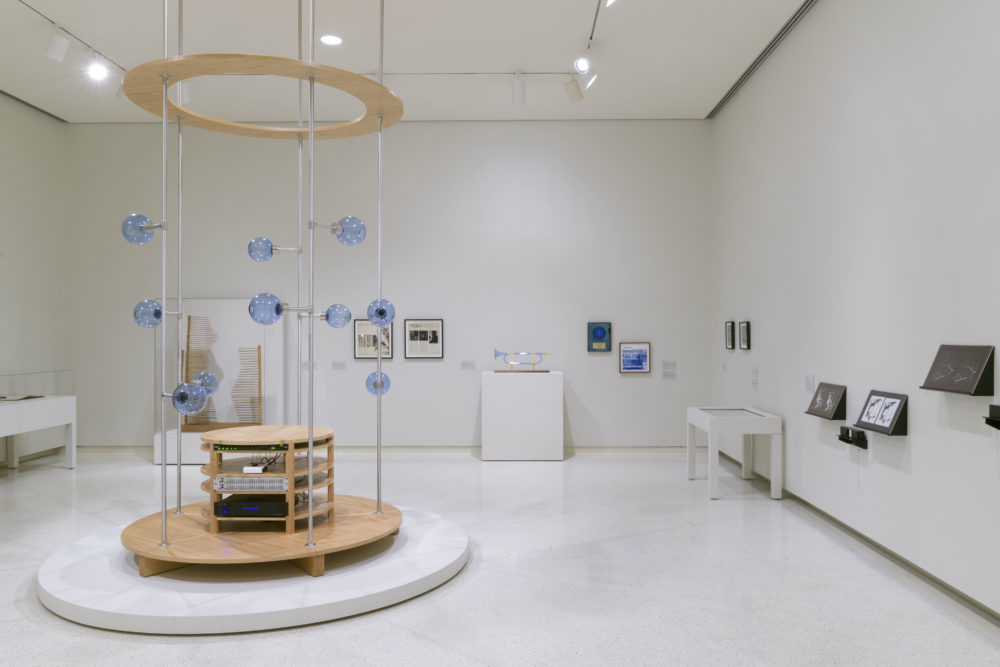 A gallery with white walls that includes various artwork installations.