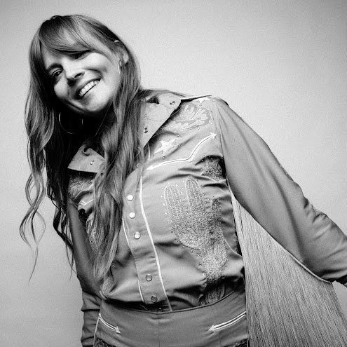 Woman smiling and happy wearing a country western shirt.