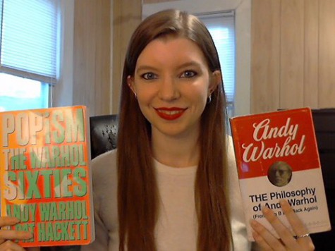 Blog Author Grace Marston holds up a copy of the books Popism and Andy Warhol: THE Philosophy of Andy Warhol.