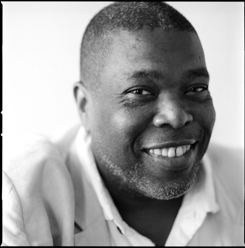 Head shot of a person with a white shirt smiling at the camera.