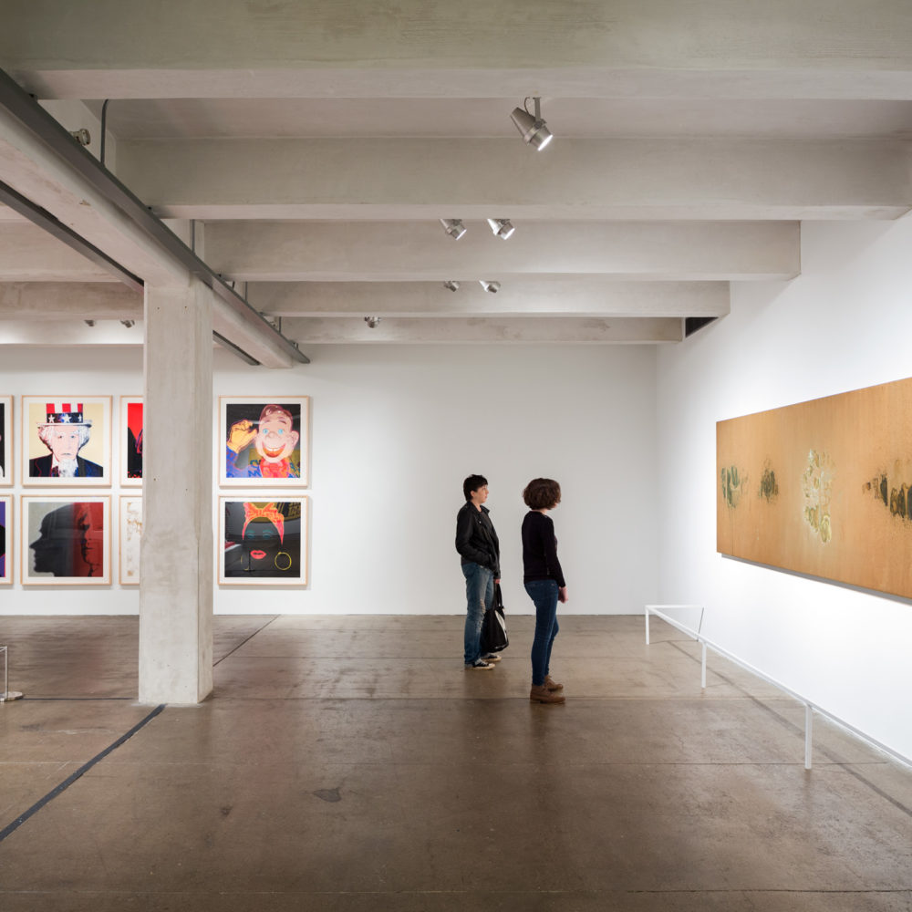 Two visitors examine a large oxidation painting in The 168极速赛车开奖官方开奖网 Warhol Museum.