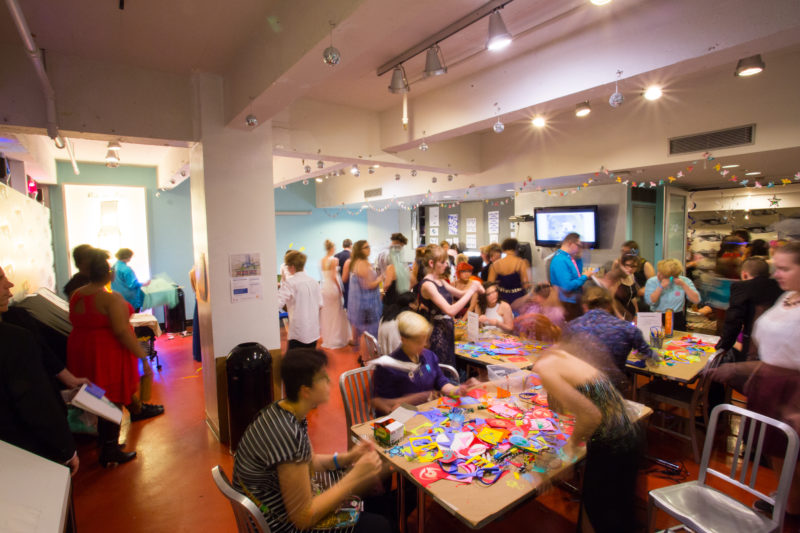 A crowd of teens in an art studio working on various hands-on artmaking activities.