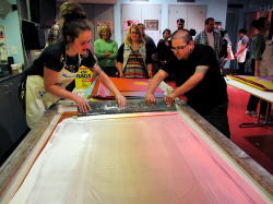 Two people screen printing