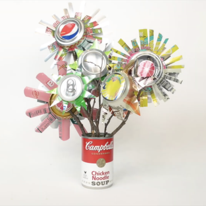 Can of soup with flowers made from cray paper sprouting from the top.