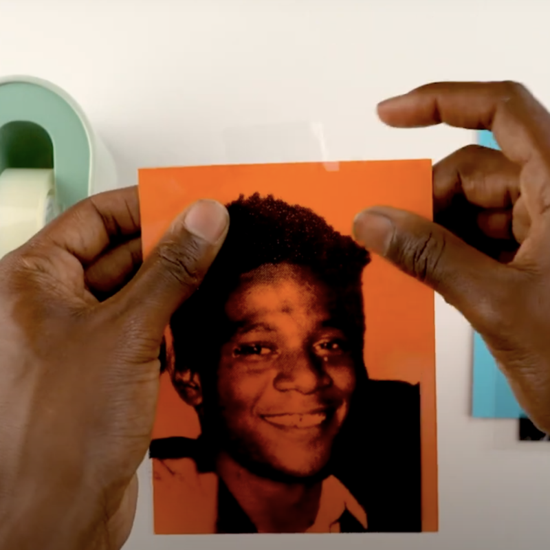 Close-up of a man's hands holding paper ready to make a collage.