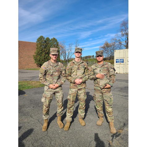 Three men in military uniforms posing in front of the camera